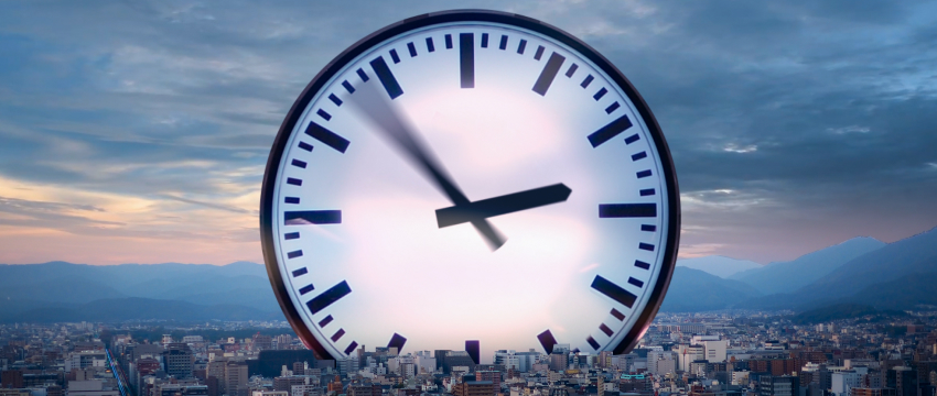 Un reloj muestra la hora frente al horizonte de una ciudad, simbolizando los horarios del mercado para el trading de forex.