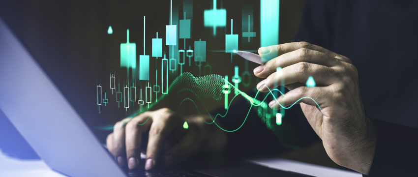 Une personne analysant des graphiques Forex sur un ordinateur portable, concentrée sur le graphique affiché.